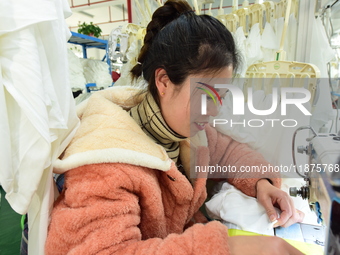 A female worker produces garments for export at a workshop in Lianyungang, China, on December 17, 2024. (