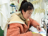 A female worker produces garments for export at a workshop in Lianyungang, China, on December 17, 2024. (