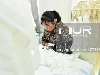 A female worker produces garments for export at a workshop in Lianyungang, China, on December 17, 2024. (