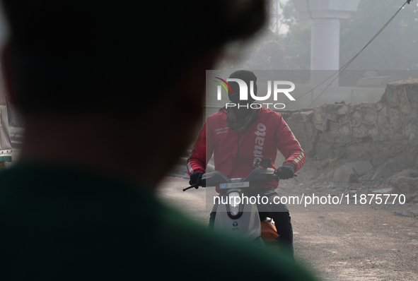 A Zomato food delivery agent wears a face mask on his bike as the air quality index slips to the 'severe' category in New Delhi, India, on D...