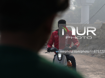 A Zomato food delivery agent wears a face mask on his bike as the air quality index slips to the 'severe' category in New Delhi, India, on D...