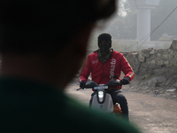 A Zomato food delivery agent wears a face mask on his bike as the air quality index slips to the 'severe' category in New Delhi, India, on D...