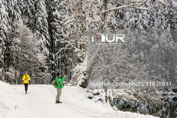 Hikers are at Eibsee in Grainau, Bavaria, Germany, on December 13, 2024. The lake is located 9 km southwest of Garmisch-Partenkirchen below...