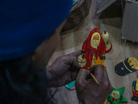 Muzaffar Hussain Dar, a Kashmiri artisan, paints Christmas gift items at the workshop before sending them to the market ahead of Christmas c...