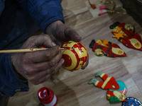 Muzaffar Hussain Dar, a Kashmiri artisan, paints Christmas gift items at the workshop before sending them to the market ahead of Christmas c...