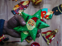 Muzaffar Hussain Dar, a Kashmiri artisan, paints Christmas gift items at the workshop before sending them to the market ahead of Christmas c...