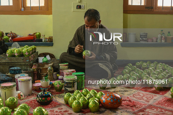 Fida Hussain Parray, a Kashmiri artisan, paints Christmas gift items at the workshop before sending them to the market ahead of Christmas ce...