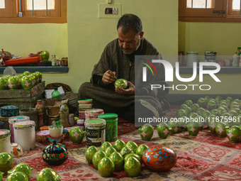 Fida Hussain Parray, a Kashmiri artisan, paints Christmas gift items at the workshop before sending them to the market ahead of Christmas ce...