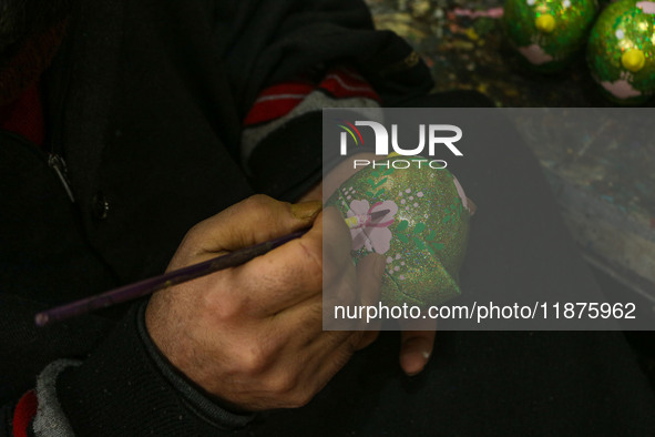 Showkat Haji, a Kashmiri artisan, paints Christmas gift items at the workshop before sending them to the market ahead of Christmas celebrati...