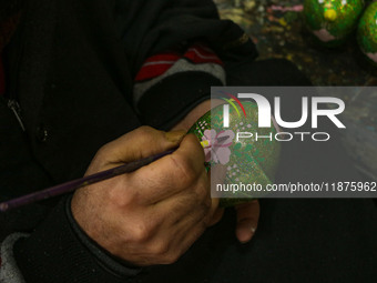 Showkat Haji, a Kashmiri artisan, paints Christmas gift items at the workshop before sending them to the market ahead of Christmas celebrati...