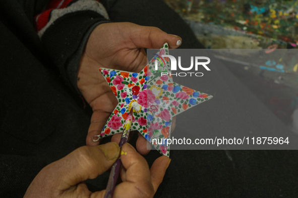 Showkat Haji, a Kashmiri artisan, paints Christmas gift items at the workshop before sending them to the market ahead of Christmas celebrati...