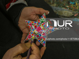 Showkat Haji, a Kashmiri artisan, paints Christmas gift items at the workshop before sending them to the market ahead of Christmas celebrati...