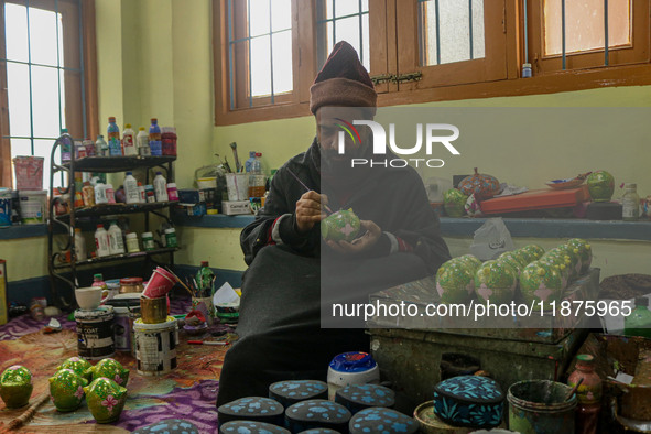 Showkat Haji, a Kashmiri artisan, paints Christmas gift items at the workshop before sending them to the market ahead of Christmas celebrati...