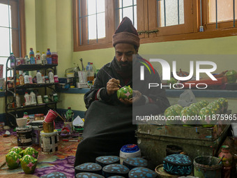 Showkat Haji, a Kashmiri artisan, paints Christmas gift items at the workshop before sending them to the market ahead of Christmas celebrati...