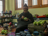 Showkat Haji, a Kashmiri artisan, paints Christmas gift items at the workshop before sending them to the market ahead of Christmas celebrati...