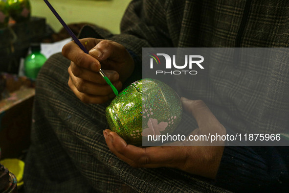 Fida Hussain Parray, a Kashmiri artisan, paints Christmas gift items at the workshop before sending them to the market ahead of Christmas ce...