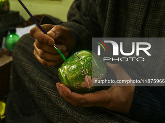 Fida Hussain Parray, a Kashmiri artisan, paints Christmas gift items at the workshop before sending them to the market ahead of Christmas ce...