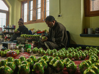 Showkat Haji (left) and Fida Hussain Parray (right), Kashmiri artisans, paint Christmas gift items at the workshop before sending them to th...