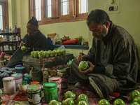 Showkat Haji (left) and Fida Hussain Parray (right), Kashmiri artisans, paint Christmas gift items at the workshop before sending them to th...