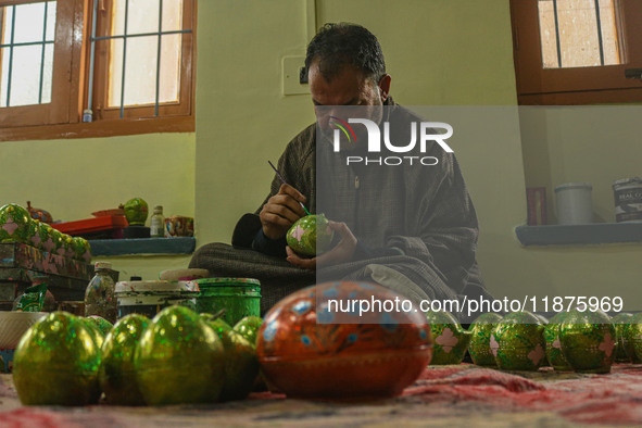 Fida Hussain Parray, a Kashmiri artisan, paints Christmas gift items at the workshop before sending them to the market ahead of Christmas ce...