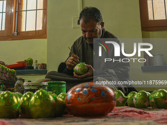 Fida Hussain Parray, a Kashmiri artisan, paints Christmas gift items at the workshop before sending them to the market ahead of Christmas ce...