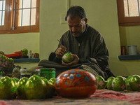 Fida Hussain Parray, a Kashmiri artisan, paints Christmas gift items at the workshop before sending them to the market ahead of Christmas ce...