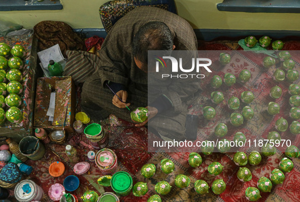 Fida Hussain Parray, a Kashmiri artisan, paints Christmas gift items at the workshop before sending them to the market ahead of Christmas ce...