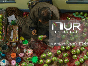 Fida Hussain Parray, a Kashmiri artisan, paints Christmas gift items at the workshop before sending them to the market ahead of Christmas ce...