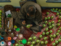 Fida Hussain Parray, a Kashmiri artisan, paints Christmas gift items at the workshop before sending them to the market ahead of Christmas ce...