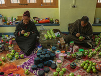 Showkat Haji (left) and Fida Hussain Parray (right), Kashmiri artisans, paint Christmas gift items at the workshop before sending them to th...