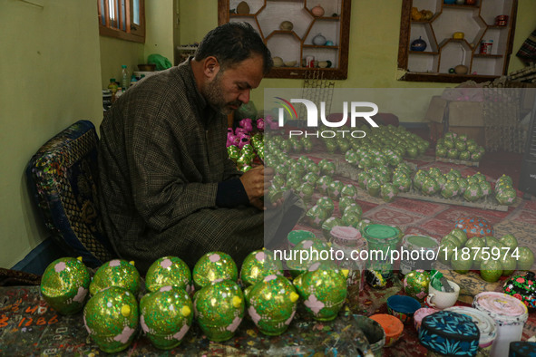 Fida Hussain Parray, a Kashmiri artisan, paints Christmas gift items at the workshop before sending them to the market ahead of Christmas ce...