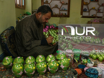 Fida Hussain Parray, a Kashmiri artisan, paints Christmas gift items at the workshop before sending them to the market ahead of Christmas ce...