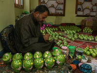 Fida Hussain Parray, a Kashmiri artisan, paints Christmas gift items at the workshop before sending them to the market ahead of Christmas ce...