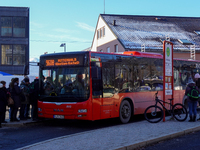 Passengers board the regional bus at Garmisch-Partenkirchen Train Station in Bavaria, Germany, on December 13, 2024. A bright red regional b...