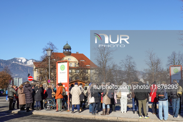 A busy winter day occurs at Garmisch-Partenkirchen Train Station in Bavaria, Germany, on December 13, 2024. Travelers gather at a bus stop n...