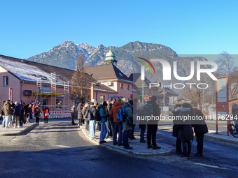 A busy winter day occurs at Garmisch-Partenkirchen Train Station in Bavaria, Germany, on December 13, 2024. Travelers gather at a bus stop n...