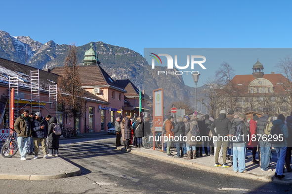 A busy winter day occurs at Garmisch-Partenkirchen Train Station in Bavaria, Germany, on December 13, 2024. Travelers gather at a bus stop n...