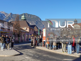 A busy winter day occurs at Garmisch-Partenkirchen Train Station in Bavaria, Germany, on December 13, 2024. Travelers gather at a bus stop n...