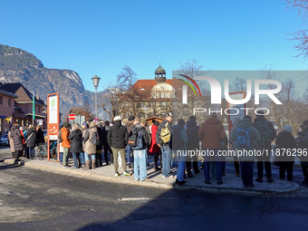 A busy winter day occurs at Garmisch-Partenkirchen Train Station in Bavaria, Germany, on December 13, 2024. Travelers gather at a bus stop n...