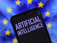 The text 'Artificial Intelligence (AI)' appears on a smartphone screen in this illustration photo, and in the background is the flag of the...