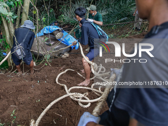 Workers and officials remove the carcass of a 45-year-old female Sumatran elephant named Molly, found dead at a riverbank after being carrie...