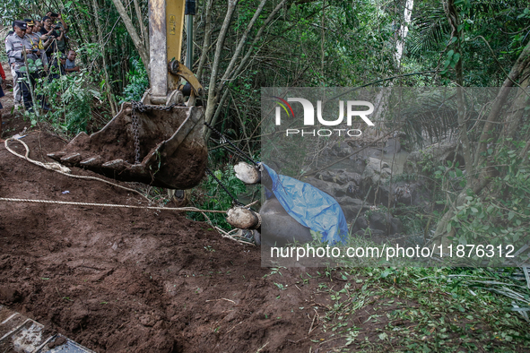 Workers and officials remove the carcass of a 45-year-old female Sumatran elephant named Molly, found dead at a riverbank after being carrie...