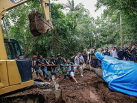 Workers and officials remove the carcass of a 45-year-old female Sumatran elephant named Molly, found dead at a riverbank after being carrie...