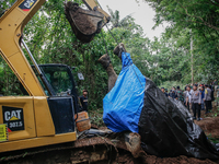 Workers and officials remove the carcass of a 45-year-old female Sumatran elephant named Molly, found dead at a riverbank after being carrie...