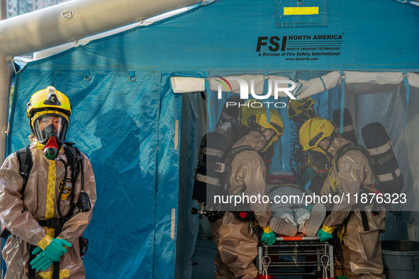 Firefighters decontaminate a person at Kai Tak Sports Park during a counter-terrorism exercise in Hong Kong on December 17, 2024. 