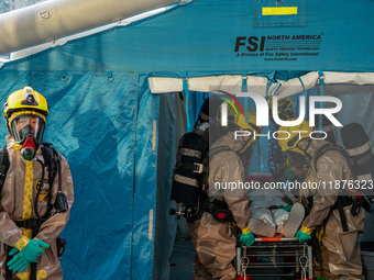 Firefighters decontaminate a person at Kai Tak Sports Park during a counter-terrorism exercise in Hong Kong on December 17, 2024. (