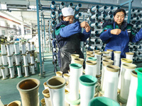 Workers sort warp threads for industrial textiles at a textile production line in Zhangye, China, on December 17, 2024. (