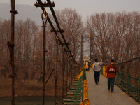 People walk on a footbridge on a cold winter day in Baramulla, Jammu and Kashmir, India, on December 17, 2024. (