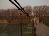 People walk on a footbridge on a cold winter day in Baramulla, Jammu and Kashmir, India, on December 17, 2024. (