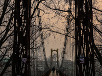 People walk on a footbridge on a cold winter day in Baramulla, Jammu and Kashmir, India, on December 17, 2024. (